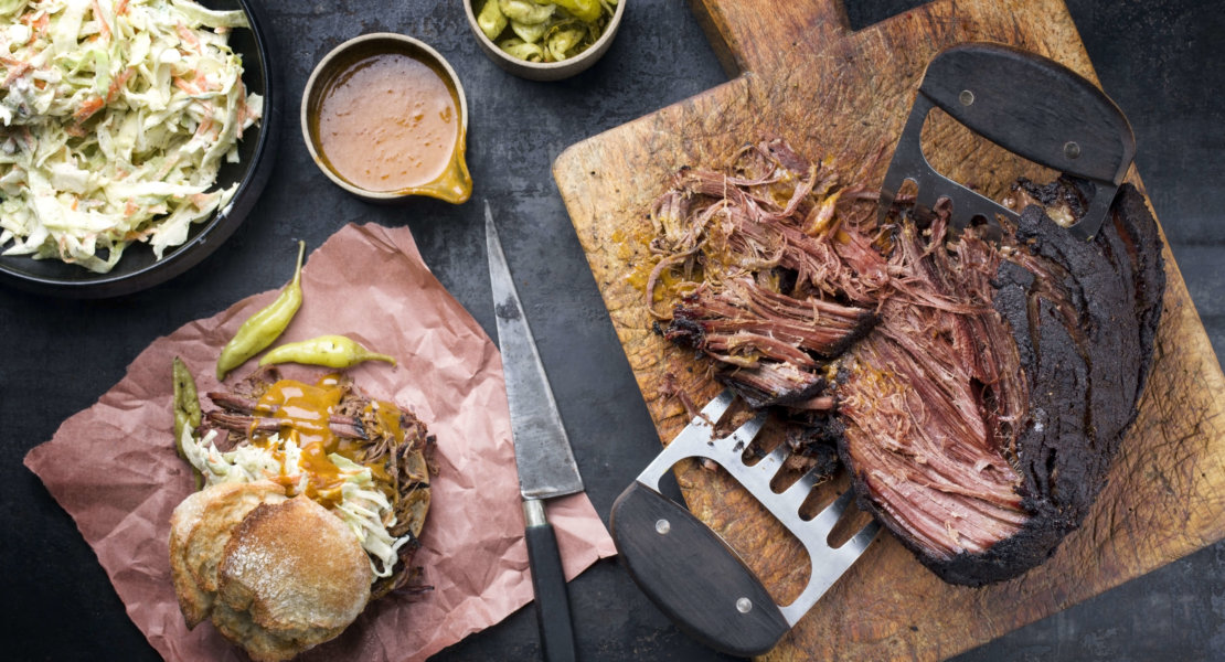 Traditional barbecue wagyu pulled beef with coleslaw  as closeup on a rustic cutting board